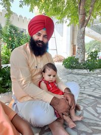 Portrait of father and son holding baby