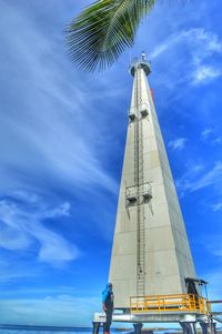 Low angle view of man tower against blue sky
