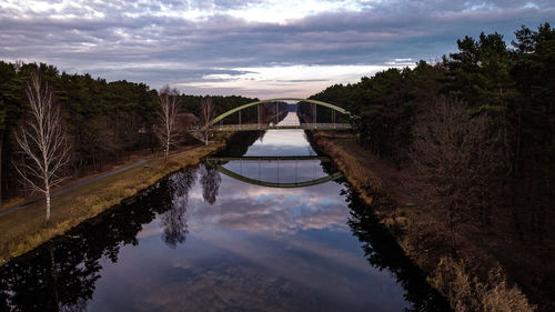 Arch bridge over river against sky