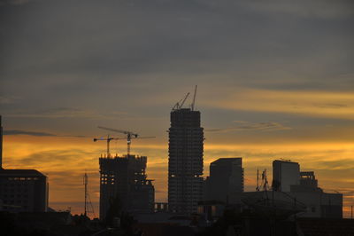 Silhouette buildings against sky during sunset