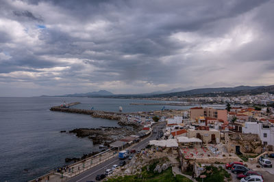 High angle view of buildings by sea against sky