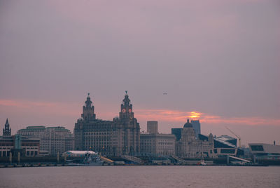 View of buildings against cloudy sky during sunset