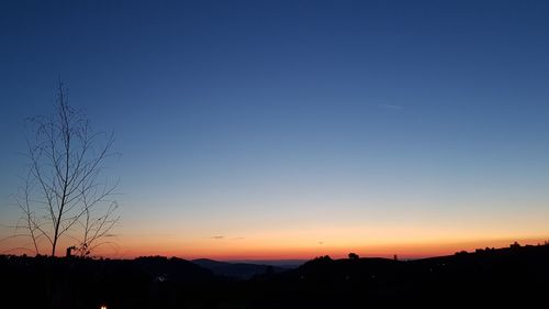 Silhouette landscape against clear sky during sunset