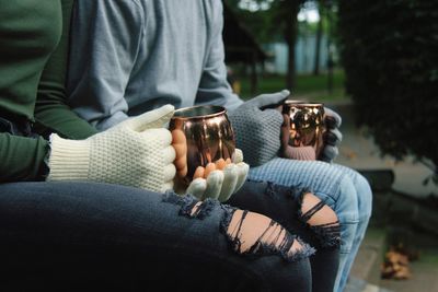 Midsection of friends holding cups during winter