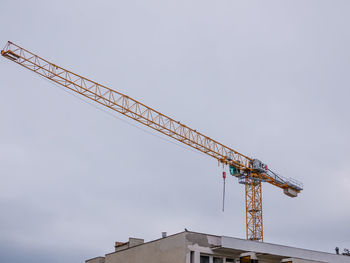 Low angle view of crane against sky