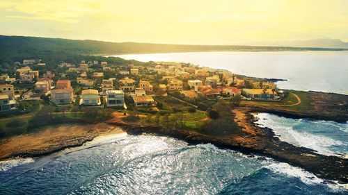 High angle view of townscape by sea against sky