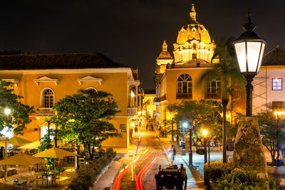 Illuminated cathedral in city against sky at night