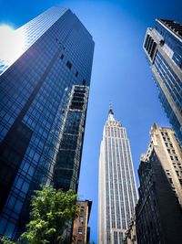 Low angle view of skyscrapers against blue sky