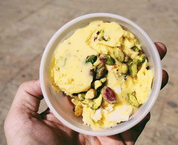 Close-up of hand holding pistachio ice cream cup