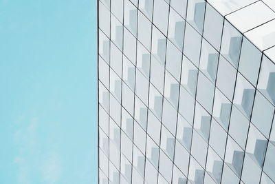 Low angle view of glass building against clear sky