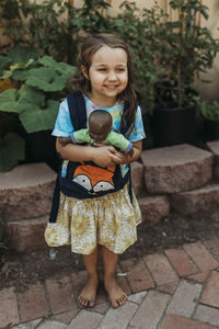 Full length of a smiling girl standing outdoors