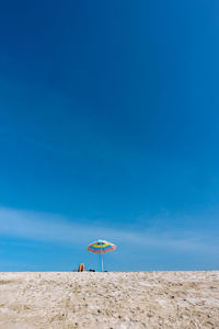 People on beach against blue sky