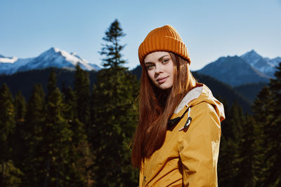 Portrait of smiling woman standing against mountain