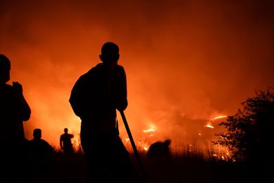 Silhouette man standing against orange sky