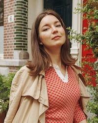 Portrait of young woman standing against plants