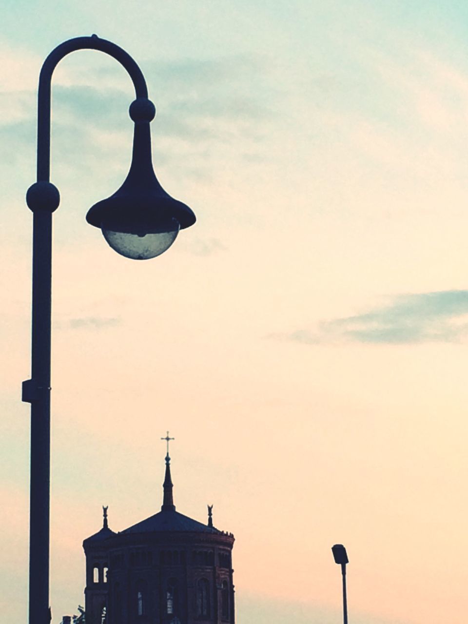 low angle view, street light, sky, building exterior, built structure, architecture, lighting equipment, high section, cloud - sky, silhouette, outdoors, no people, cloud, lamp post, pole, cross, sunset, religion, day, cloudy