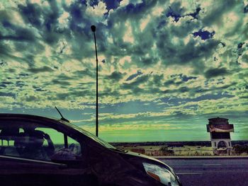 View of road against cloudy sky at sunset