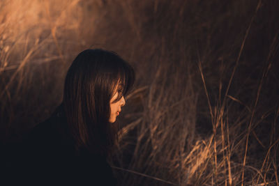 Side view of woman looking at sunset