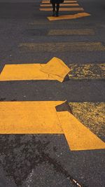 High angle view of yellow crossing sign on road