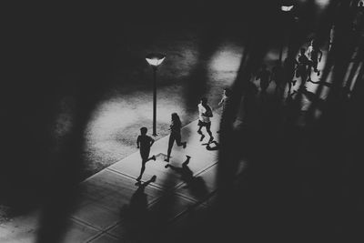 High angle view of silhouette people walking on footpath