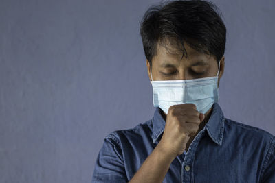 Health problem and people concept - unhealthy indian man coughing with nose mask on