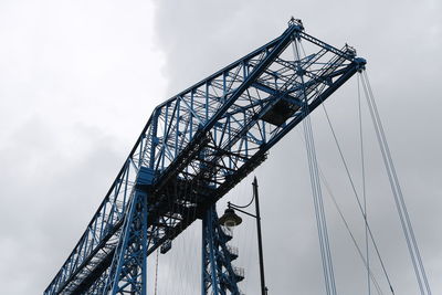 Low angle view of cranes against sky