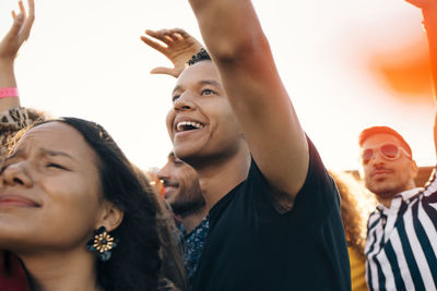 Happy young fans having fun in music concert during summer