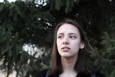 Close-up of beautiful young woman against trees
