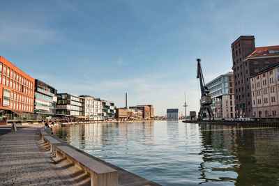 Canal amidst buildings in city against sky