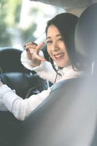 Portrait of smiling woman sitting in car