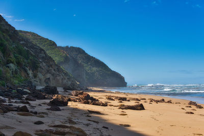 Scenic view of beach against blue sky