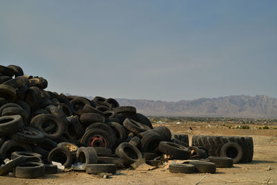 Worn-out vehicle tires piled in mojave desert with distant mountains in town of pahrump, nevada, usa