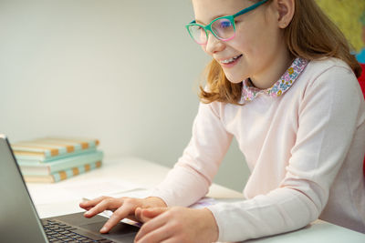 Cute girl using laptop at home