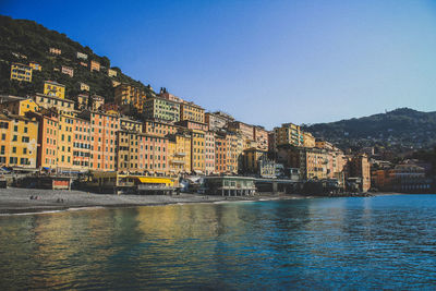 River by buildings against clear sky in city