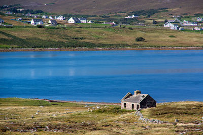 Scenic view of field by buildings against mountain