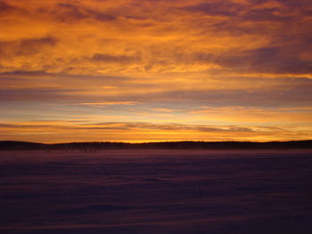 Scenic view of landscape against orange sky