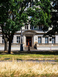 People outside house against trees and building