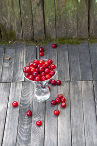 High angle view of red fruits on wood