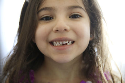 Close-up portrait of girl with gap toothed at home