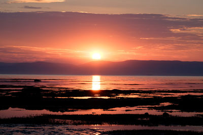 Scenic view of sea against romantic sky at sunset