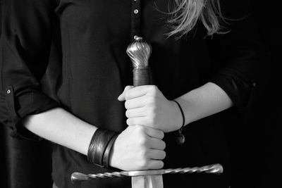 Midsection of woman holding sword