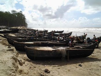 Boats moored on beach against sky