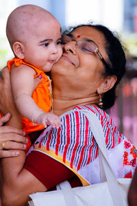 Close-up of grandmother carrying girl outdoors