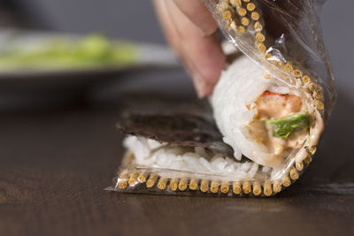 Cropped hand preparing food on wooden table