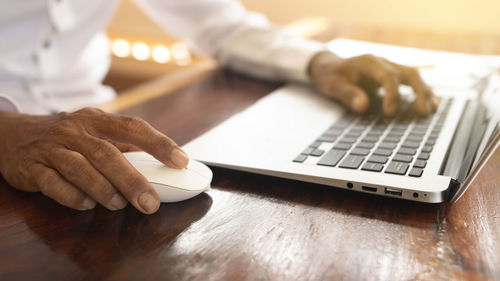 Cropped hands using laptop on table