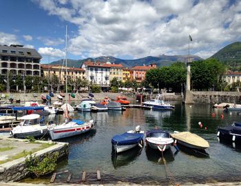 Boats moored in harbor against buildings in city