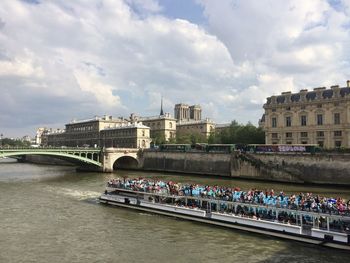 Bridge over river in city against sky