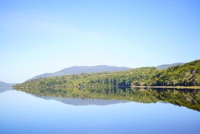 Scenic view of lake against clear blue sky