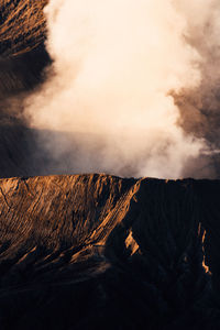 Smoke emitting from volcanic mountain against sky