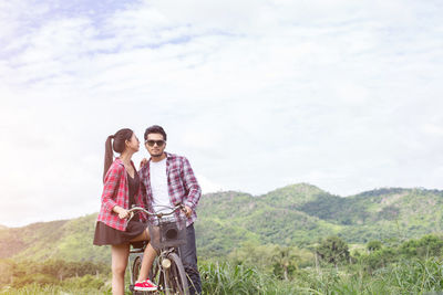 Young couple on mountain against sky